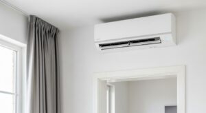 Modern indoor split air conditioning unit mounted high on a white wall